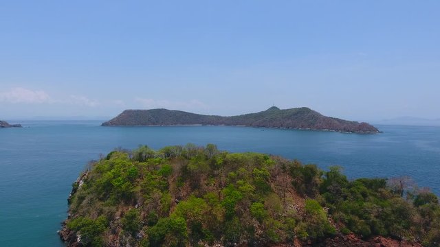 Hover Aerial View of Islands Adjacent to Bona Island Tip with Sparse Foliage, Rocky Shoreline and Bluw Sky