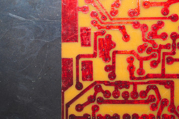 Handmade circuit board. industrial background. red soldered tracks on textolite