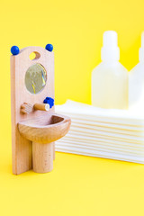 Fototapeta na wymiar Wooden toy washbasin and anti-bacterial disinfectants in white vials. Concept personal hygiene during pandemic coronavirus. Frequent and thorough hand washing