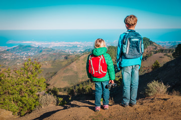 boy and girl travel in mountains, family hiking in nature