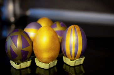 Purple golden Easter eggs on a black background
