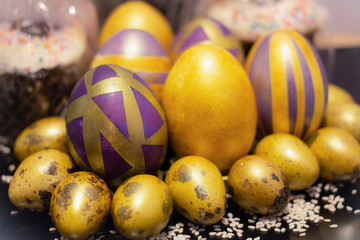 Purple golden Easter eggs on a black background