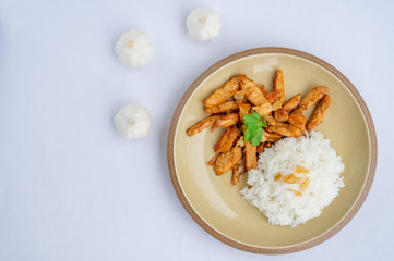 Fried meat chicken with black pepper and Garlic sauce oserved with Thai jasmine rice on the plate. isolated on white background.In Thai it call 
