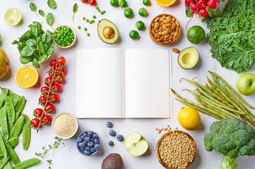 Creative flat lay with healthy vegetarian meal ingredients and empty blank notepad with copy space....