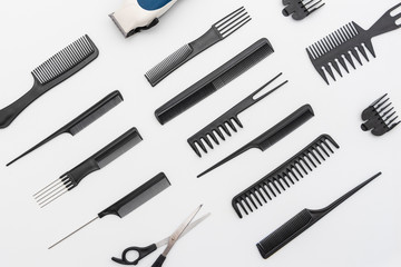 Peines , tijeras y rasuradora acomodados sobre un fondo blanco