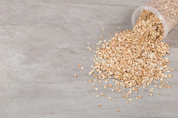 A jar of oatmeal is scattered on the table, the best food for breakfast, healthy food.