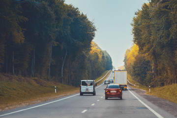 Traffic in high speed on a highway through rural landscape on sunset.