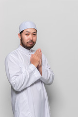 Portrait of smart handsome muslim man on white background,Greeting with respect to the Thai style
