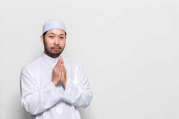 Portrait of smart handsome muslim man on white background,Greeting with respect to the Thai style
