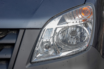 Closeup headlight optics of a small truck.