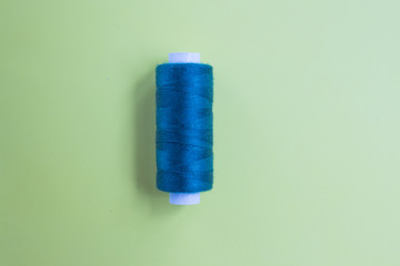 Blue indigo threads on a green background close-up. Needlework and hobby concept. Top view. Flat lay composition