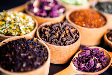 Various dried tea leaves in wooden bowl. Dried herbs tea leaves close up. Different dry herbs and...
