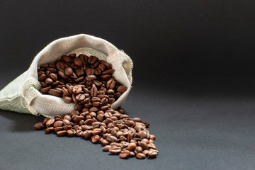 fresh coffee beans sprinkled from a bag on a black background