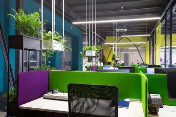 Empty place for worker in big office decorated with plants