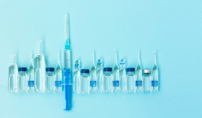 injection ampoules, syringe for vaccination on a blue background, healthcare coronavirus, cancer, painand treatment, pharmaceutical medicine concept .