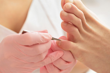 Professional pedicure using special nail intrument.Patient visiting podiatrist.Medical pedicure...
