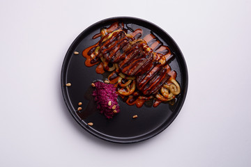 Roast meat and vegetables on a white plate. Meat dish with side dish close-up. Cranberry sauce for meat. Restaurant menu. A plate of food on a white tablecloth. Cook's job.