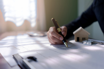 Real estate agent using a pen Sign house purchase contract.