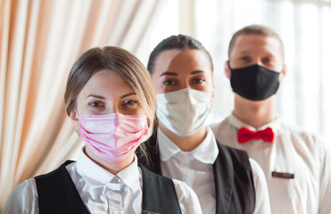 work of a waiter in a restaurant in a medical mask.