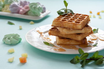 Viennese waffles with caramel topping. Still-life. Sweets, dessert with coffee.
