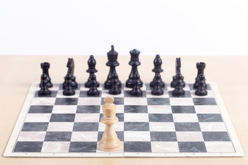 Close up of chess board with all the black pieces at start position and white king standing alone