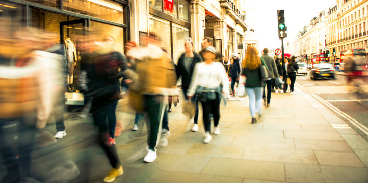 Motion blurred people walking on busy street
