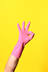 hand with glove and ok sign on yellow background