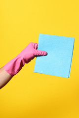 hand with baize on yellow background