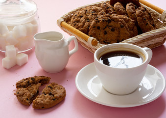 A Cup of coffee with crumbly oatmeal cookies on a pink background
