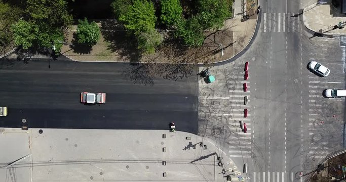 Aerial Top Down View Of Asphalting Construction Works With Commercial Repair Equipment Road Roller Compactor Machine. Contrast Between New And Old Road Surface.