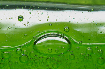 Bubbles in macro view of a green-colored bath gel