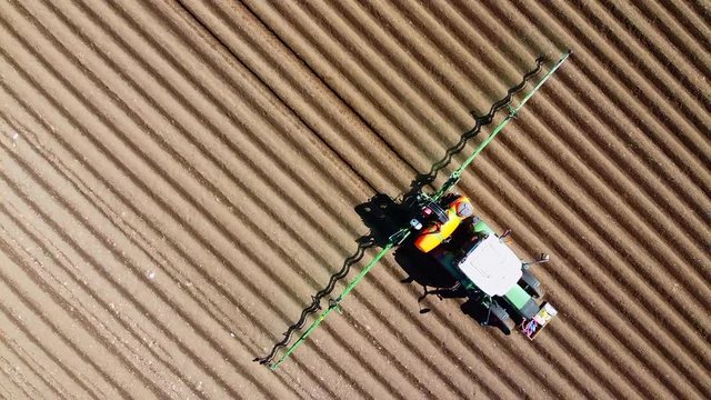 Blick auf ein Traktor biem d&uuml;ngen eines Feldes, Schweiz