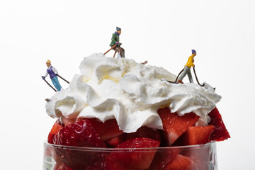Montaña de fresas con nata con esquiadores en miniatura