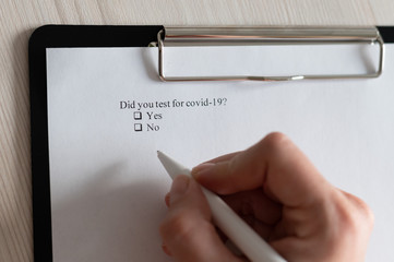 Unrecognizable woman puts a daw in the questionnaire. A close-up of a female hand answering about a...