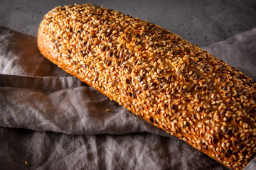 loaf of  grain bread on a gray towel on a gray background close-up, food, top view