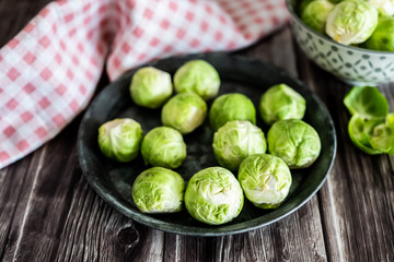 Choux de Bruxelles dans un petit bol céramique posé sur la table en bois en cuisine