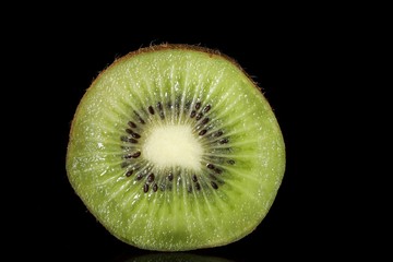 Close-up of a cut kiwi with black background