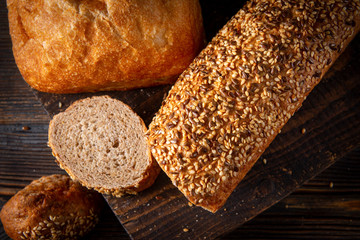 cut pieces of fresh grain bread on a wooden background close-up, top view