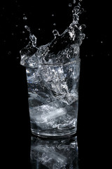 Ice falling into a glass and splashing