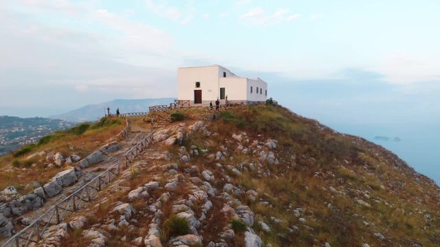 Top of the mountain, couple of tourists are walking, Shore of the Sorrento. Sunset. High view point. Vacation and travel. church Chiesa San Costanzo. place for prayers. Volcano Vesuvius, rotation