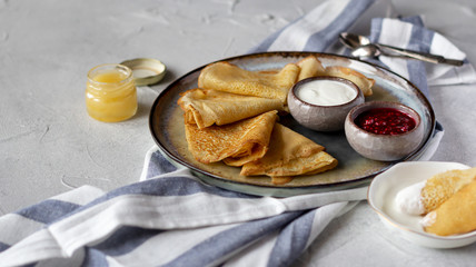 Russian crepes bliny with raspberry jam, sour cream and honey. Tasty breakfast concept
