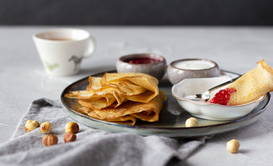 Folded thin crepes served with raspberry jam and sour cream. Tasty breakfast concept
