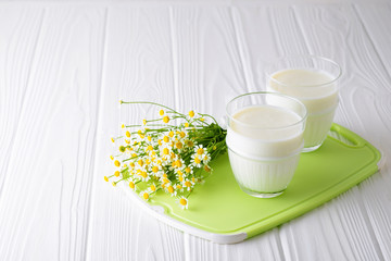 Homemade fermented dairy product kefir or yogurt with probiotics in glasses on a white wooden background with copy space
