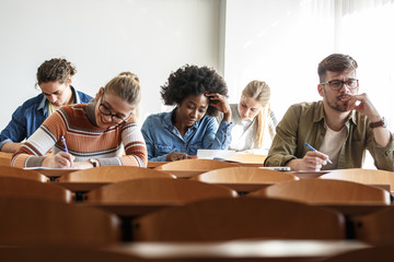 In the university classroom, students sit with focused determination, taking a test that challenges their understanding and showcases their academic progress. 