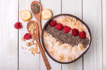 smoothie bowl with granola in a coconut bowl, top view. Healthy vegan food concept.