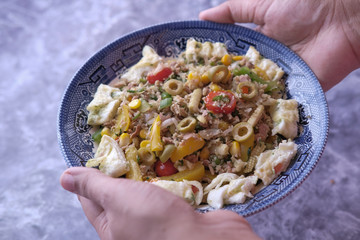 Women hand holding bowl of Fresh homemade salad 