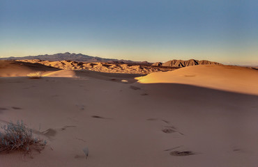 Beatiful landscape with sand dunes and mountains in  desert at sunset