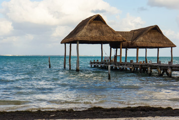 the beach with two palapas, traditional Mexican shelter with thatched roof of palm leaves 
