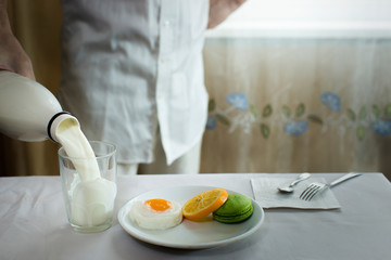 Fototapeta na wymiar milk is poured into a glass a glass during breakfast