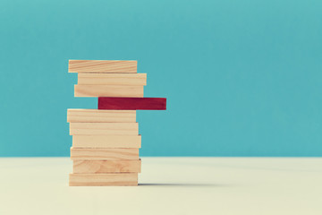 Pile of wooden blocks with one red plank. Uniqueness and originality. Think outside box. Not like...